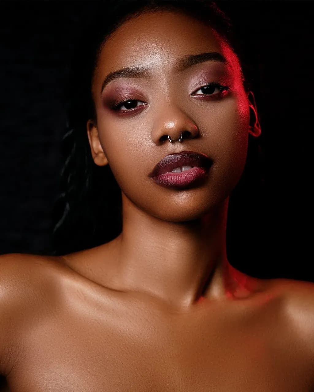 Editorial beauty portrait, lit with a red rim light